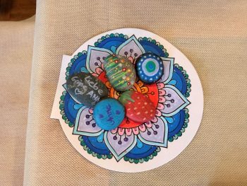"Mandala" mit bemalten Steinen drauf